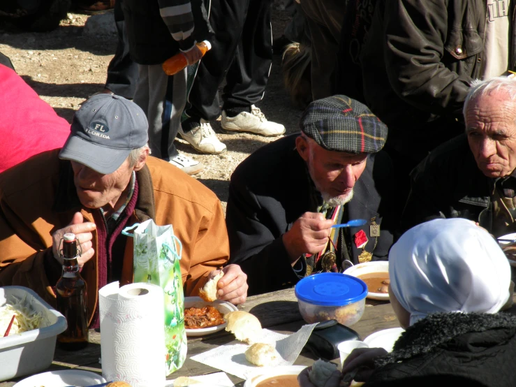 older people eating at an outdoor table during the day