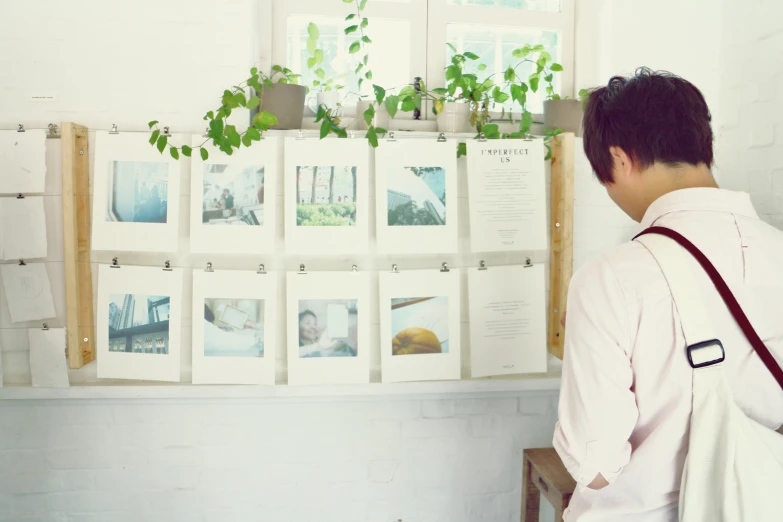 the man is holding his bag while looking at plants