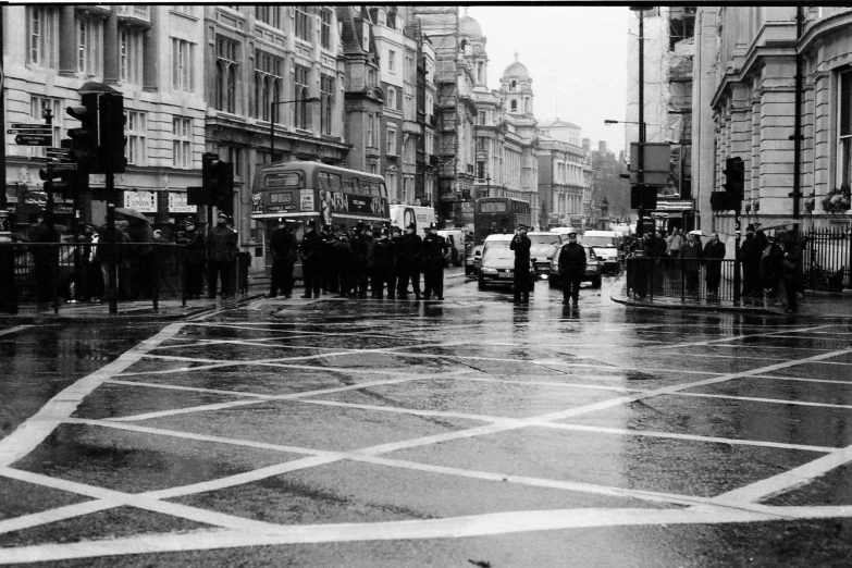 black and white po of people crossing the street in an intersection