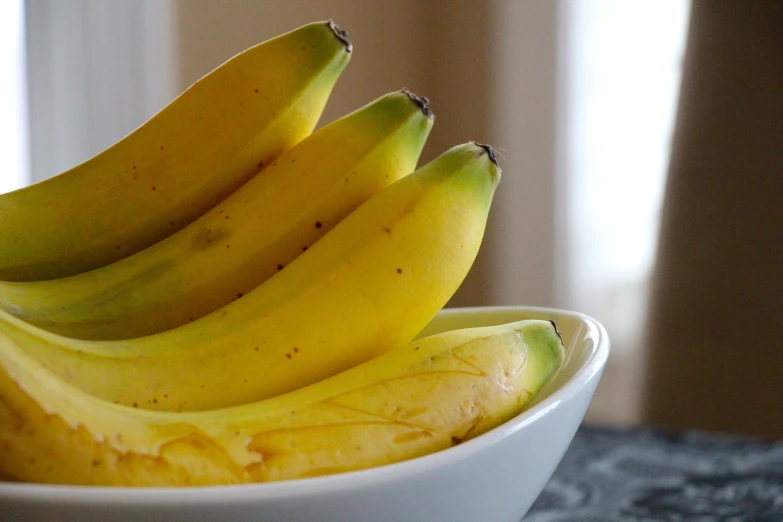 a bunch of bananas in a white bowl