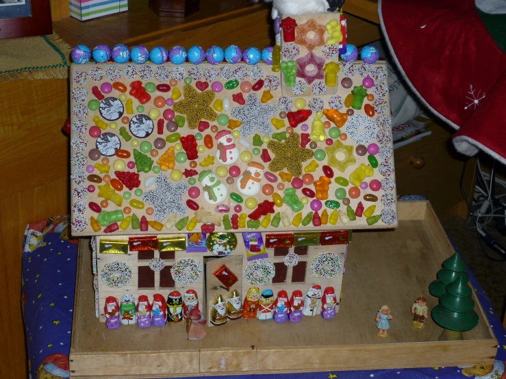 a small wooden box with a paper house made out of candy