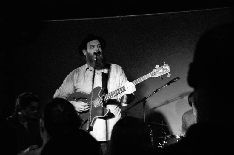 a man playing guitar and singing into a microphone