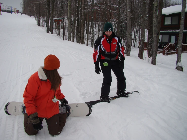 two skiers sit in the snow with their boards