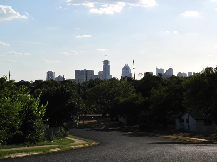 an empty street leading to a city in the distance