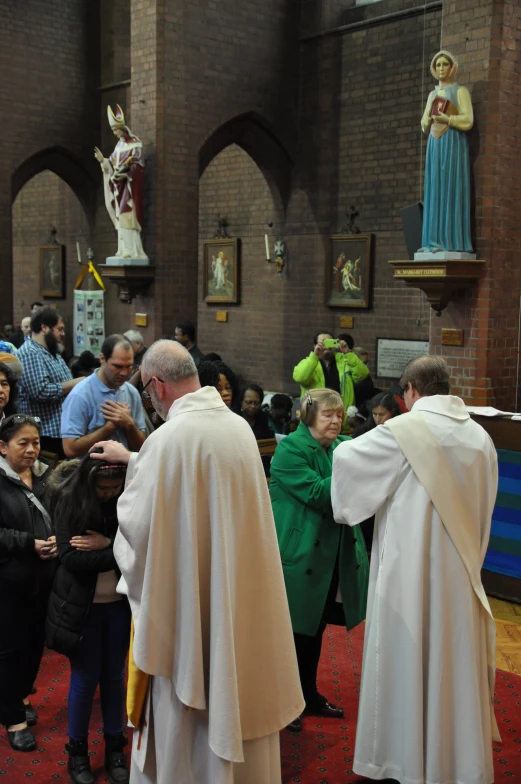 the group of people are praying in the church