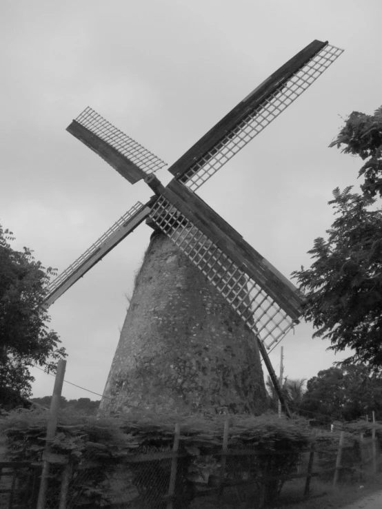 an old windmill sits next to some trees