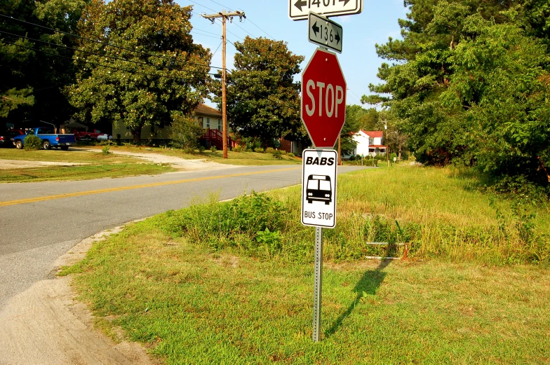 two red and white stop signs one is underneath a street sign