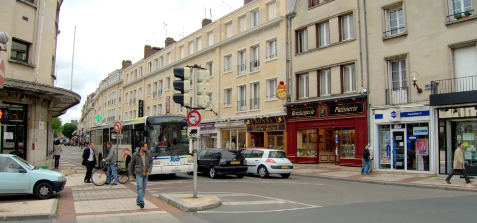 a busy street with several people crossing the intersection