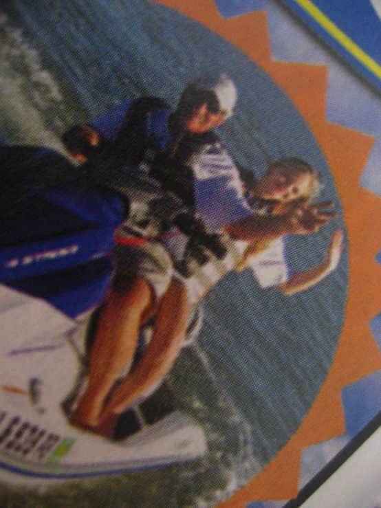 a man and woman riding a blue jet ski