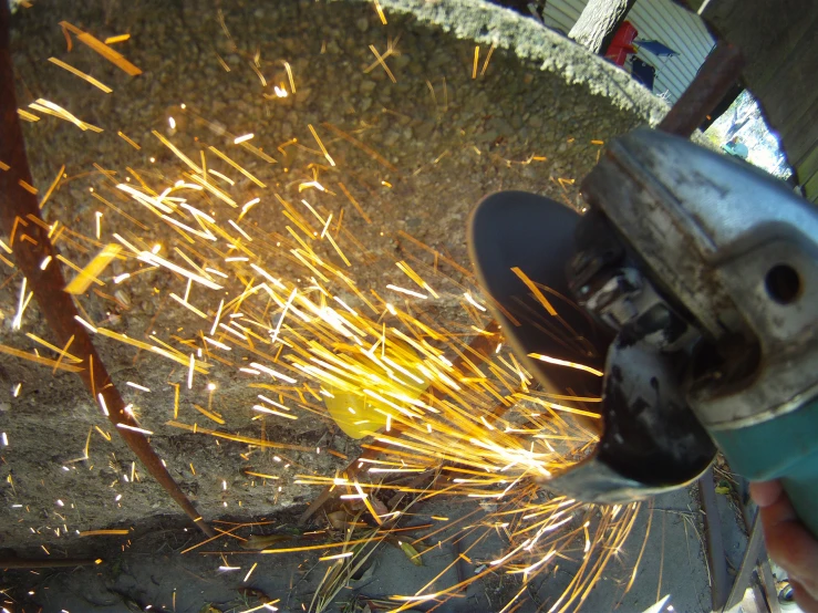 a welder cuts through sparks that have been blown into the air