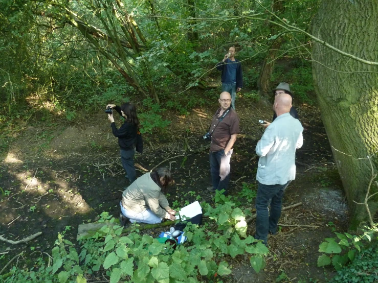 a group of people standing around in a forest