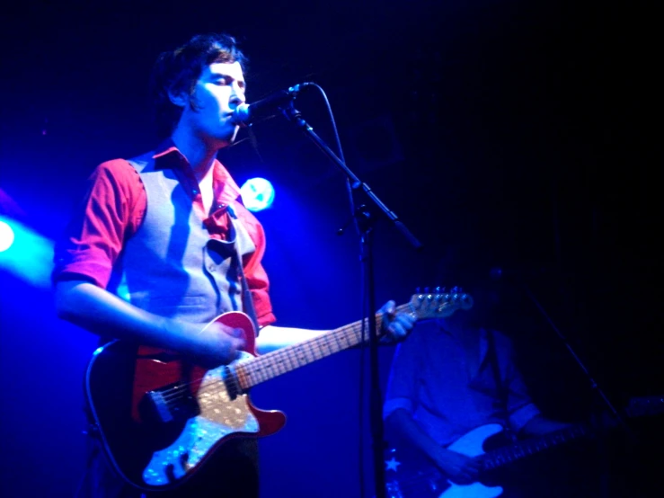 a young man playing guitar on stage