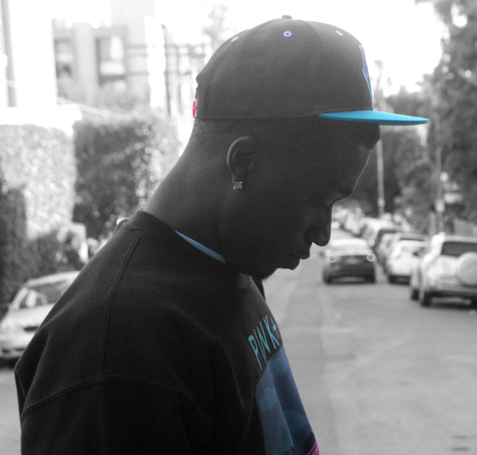 a man standing in front of a street next to some parked cars