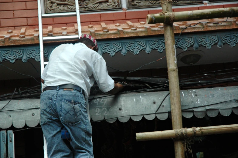 a man fixing a roof with the help of a ladder