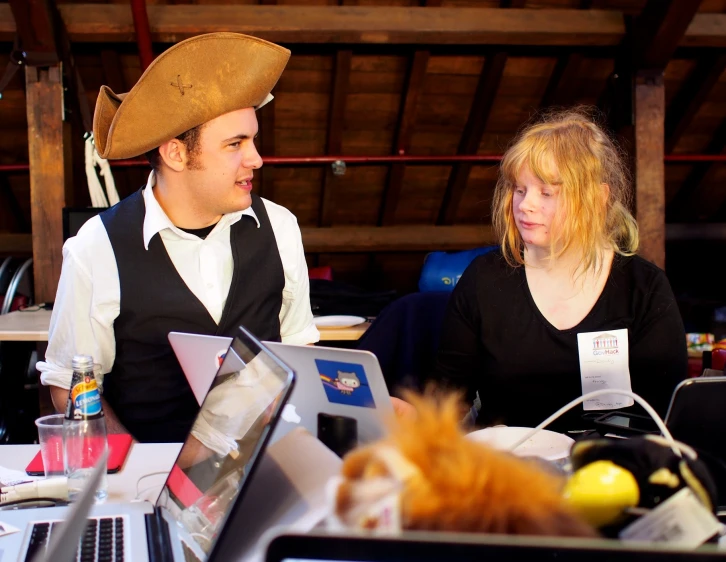 a man and woman are sitting together in front of the computer