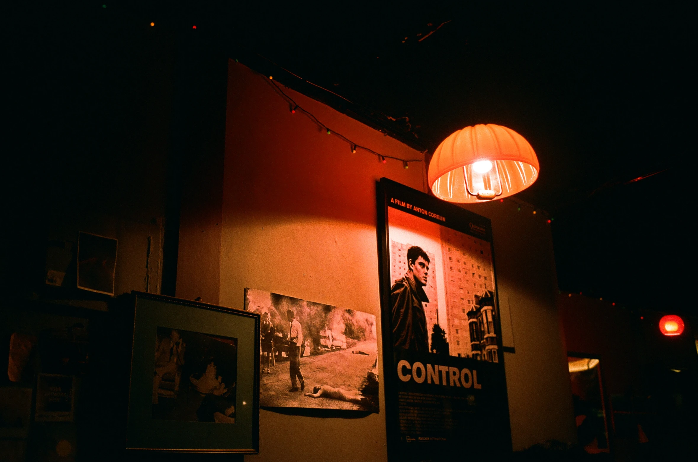 a wall covered in posters and a light hanging from it