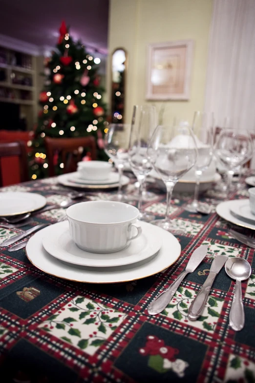 a table topped with plates and cups with silverware