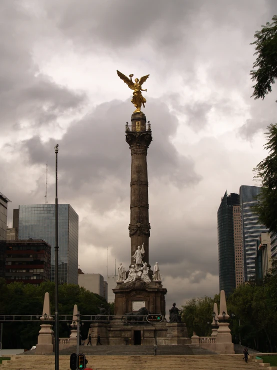 an eagle statue stands in a park near buildings