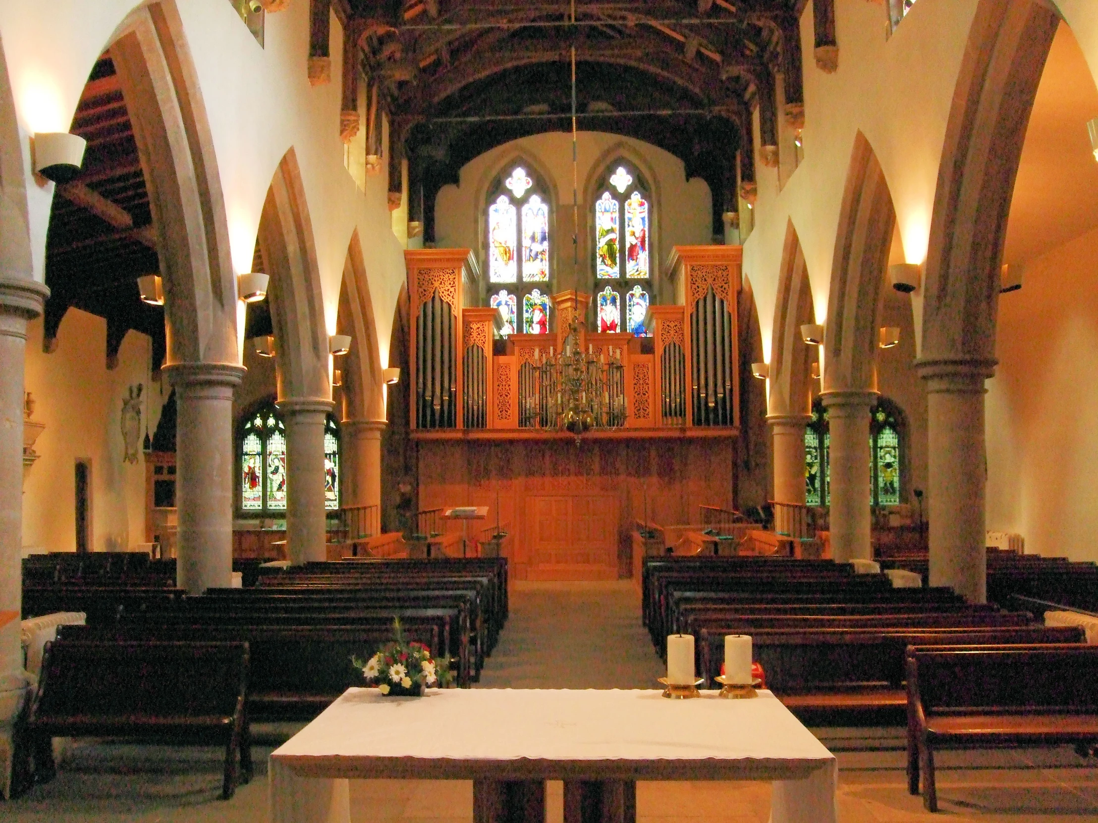 the empty pews in this church look like it is inside of a building