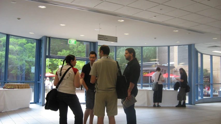 a group of people standing in front of a glass enclosed room