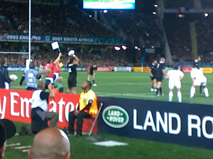 rugby players in an indoor game, in front of a crowd