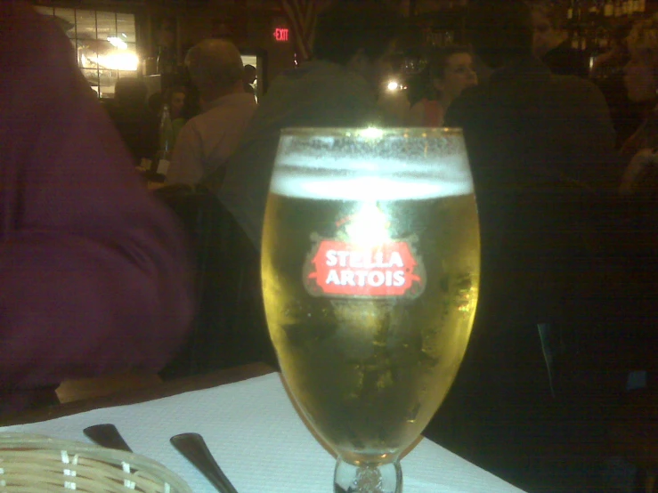 a glass filled with beer sitting on top of a table