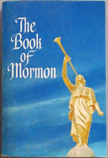 a book of mormon has gold statue holding a cross