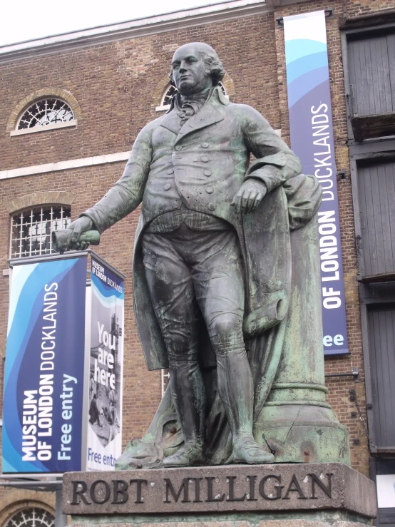 a statue in front of a building near some blue banners
