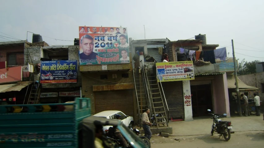 a narrow building with two cars parked in front