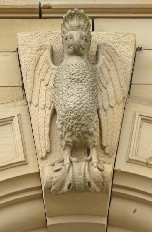 a stone bird that is on top of a building