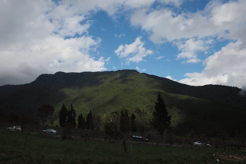 there is a car parked in the driveway beside a mountain