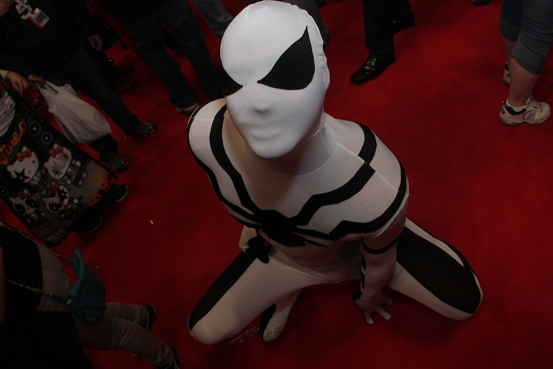 a group of people standing around a man wearing a mask