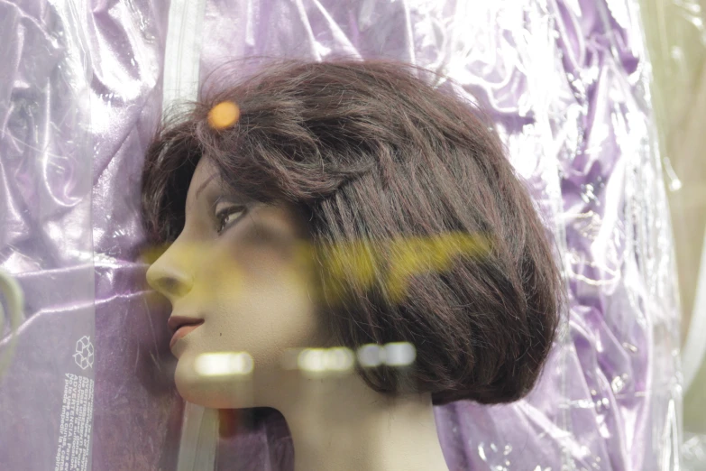 a mannequin head wearing a wig made with fake hair