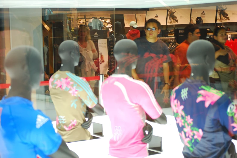 a bunch of mannequins that are wearing various colors