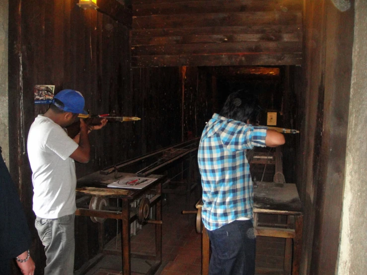 two people looking through binoculars in a room with wood