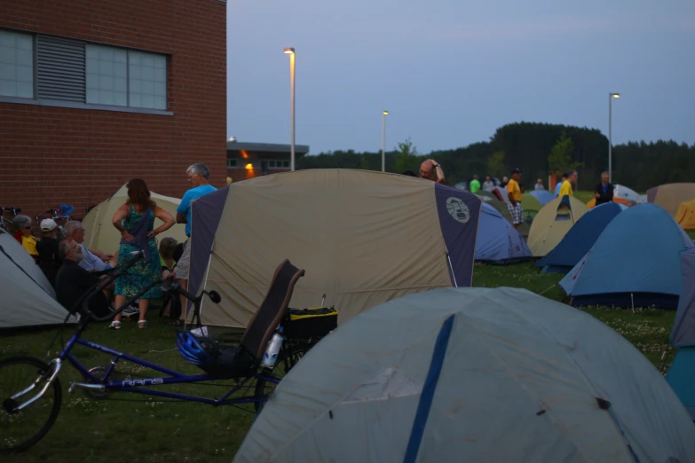 there is many tents set up outside with people walking by