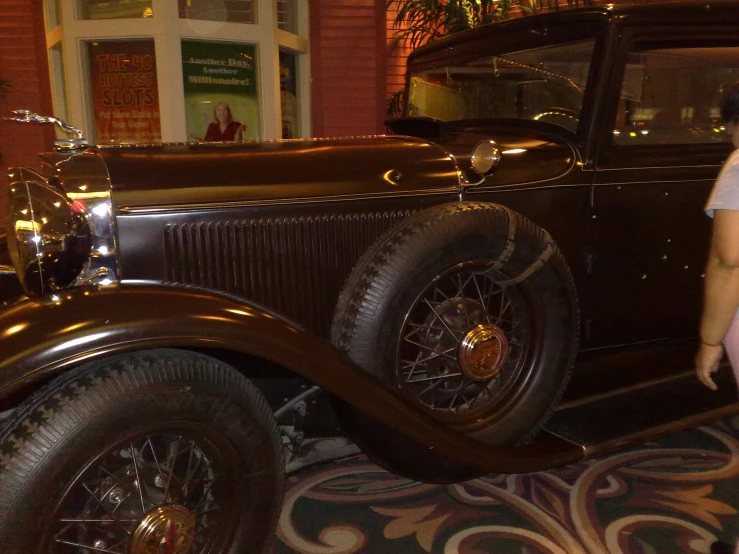 an older fashioned brown car on display at a museum