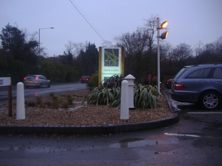 a parking lot has a sign and lights at the intersection