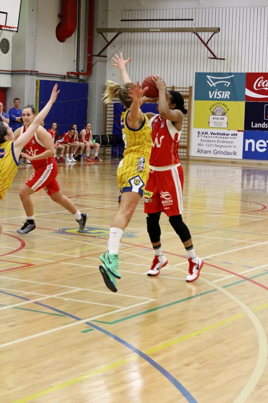 young ladies playing basketball in gymnasium during a game