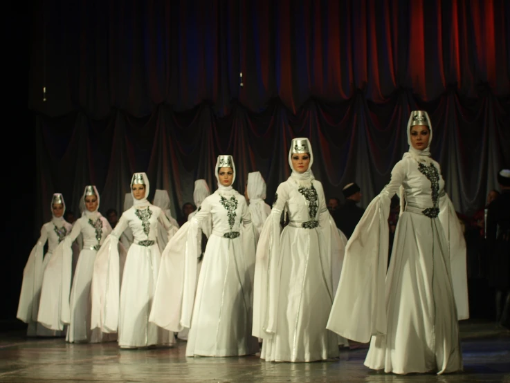 a number of people in wedding gowns on stage