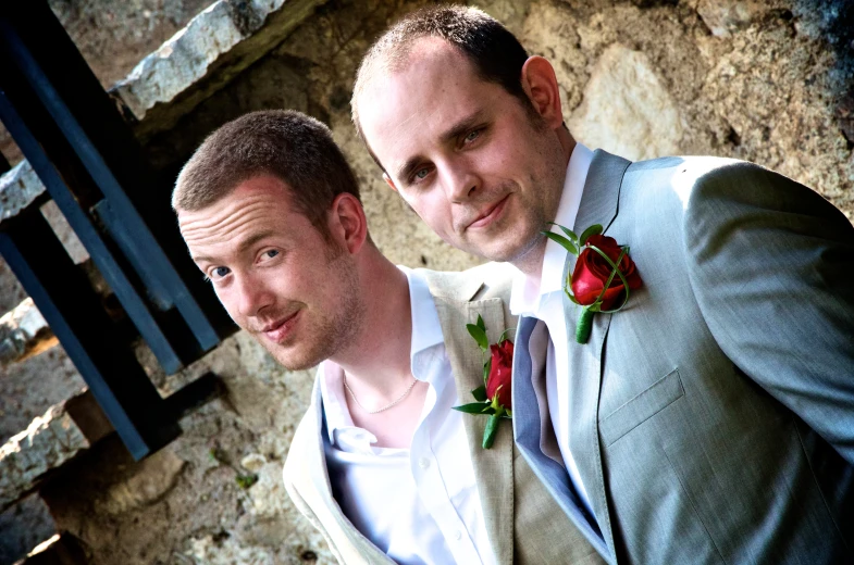 two men are standing near each other wearing suits