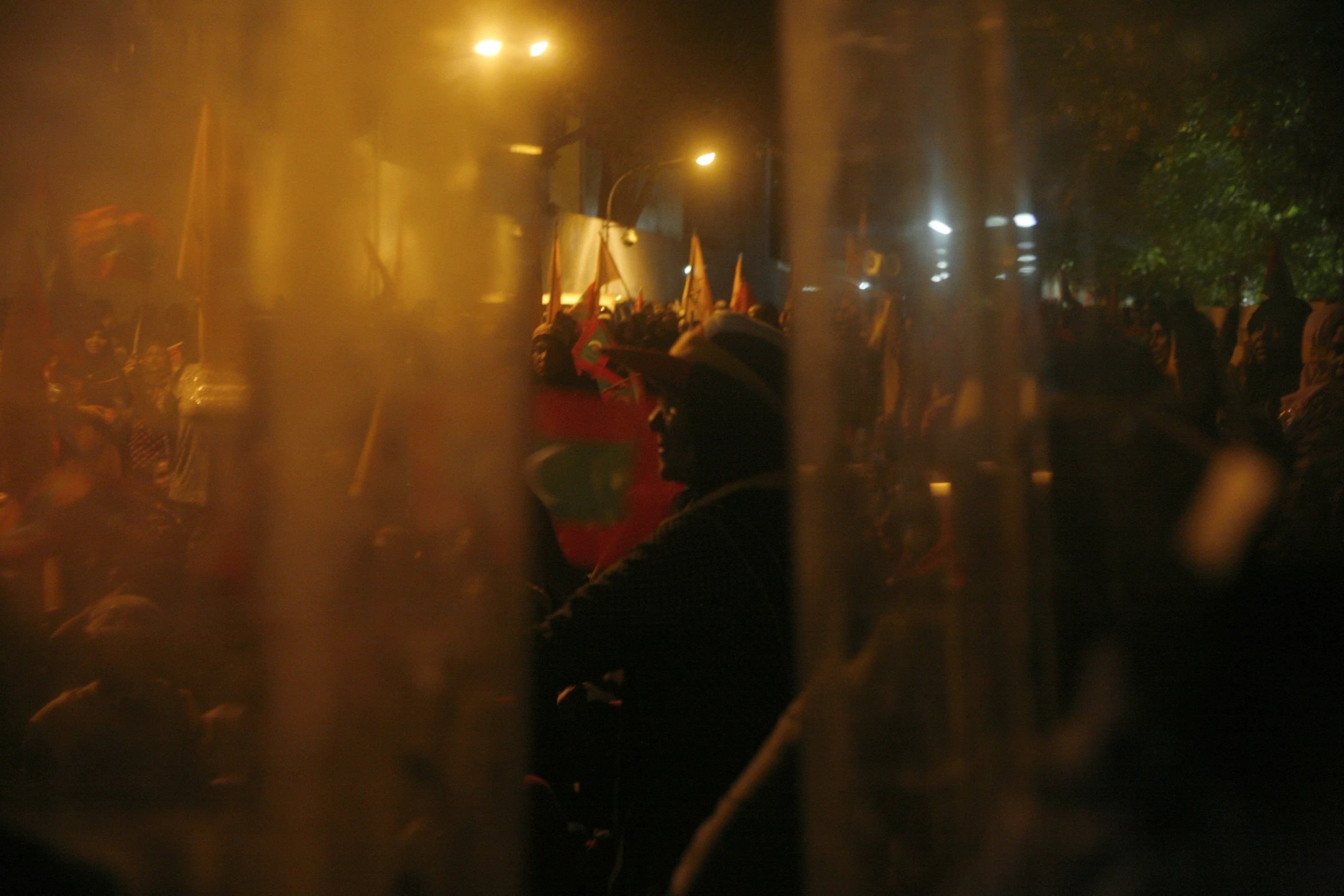 a large group of people holding candles at night