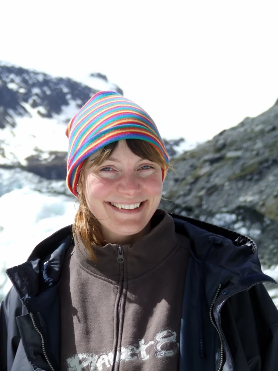 a young woman in a beanie smiles for the camera