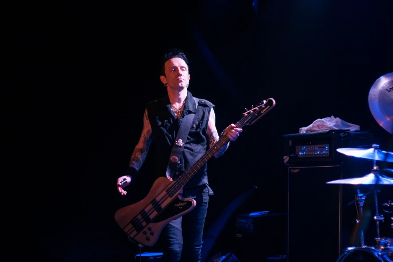 a male with a black shirt and a guitar