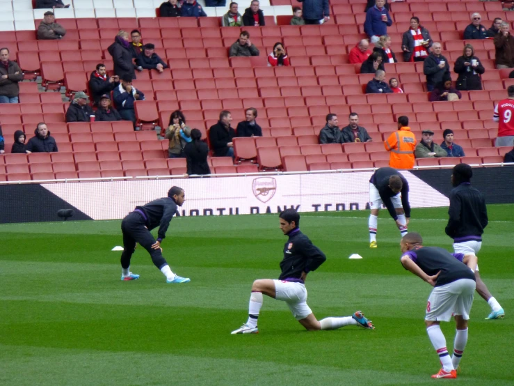 three soccer players crouch on the field