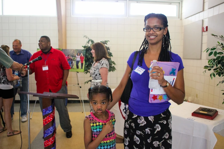 the woman stands in front of two children