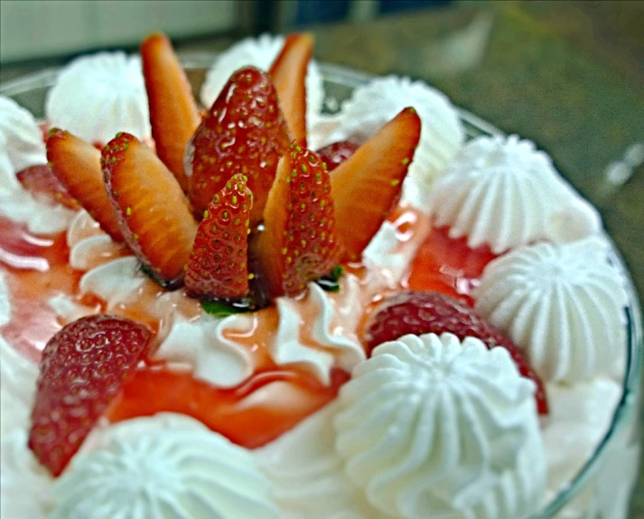 a cake with strawberries in a dish with cream and whip cream