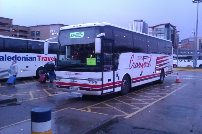 the commuter bus is parked at the side of the street