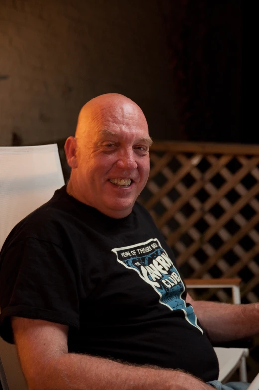 a man sits in a lounge chair wearing a shirt with an ice bear on it