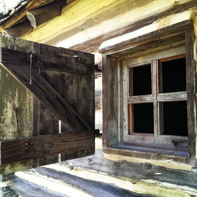 an old rustic looking wood house with shutters